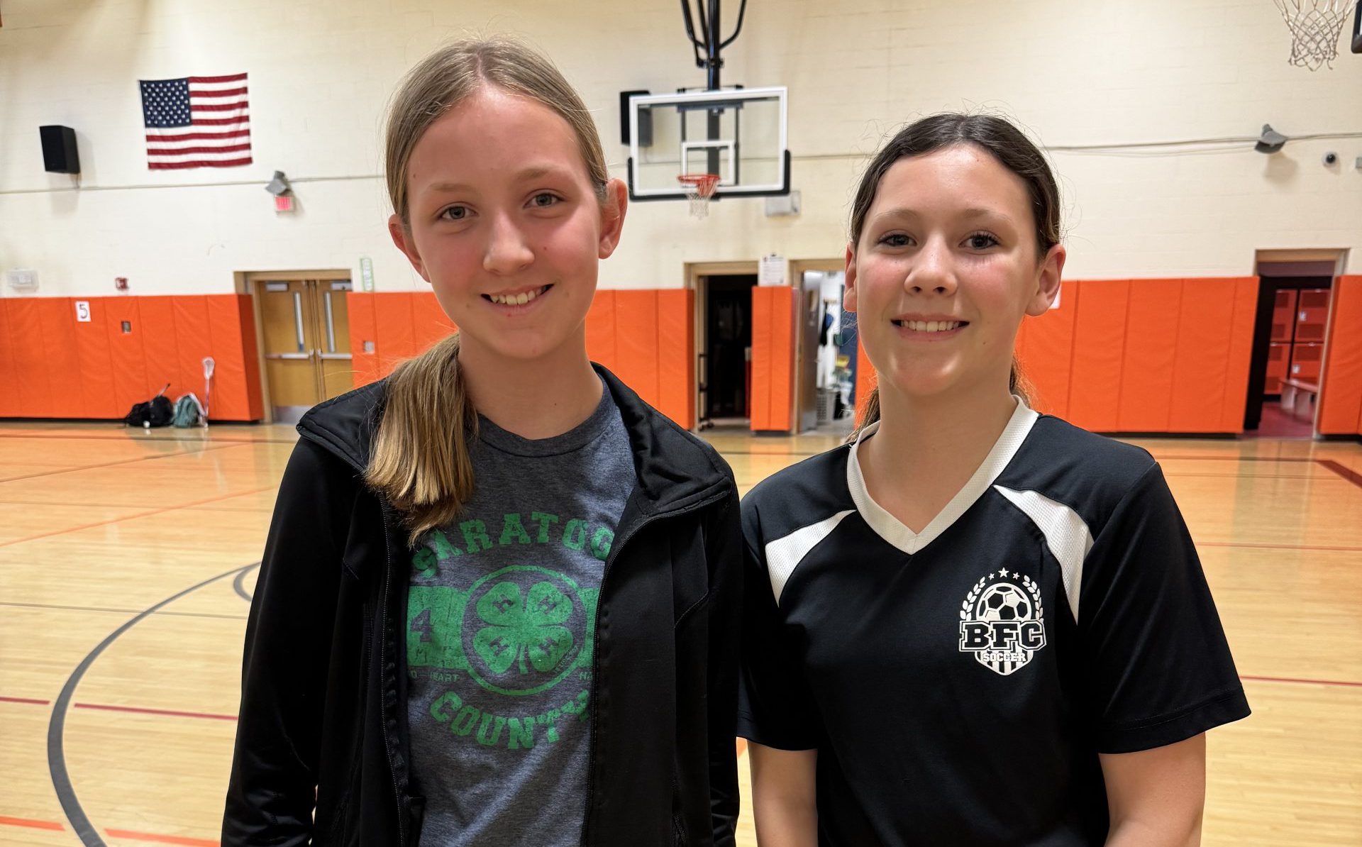 Two middle school students standing in gymnasium