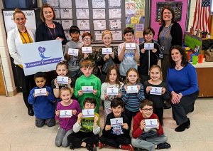 The photo depicts Rose Beckett, Elementary Principal, Stephanie Davis, 3rd Grade Teacher, Mrs. Davis' class, Cassandra Luthringer, School Counselor, and Sara Thornton, Schuylerville parent and member of the Saratoga County Chamber of Commerce.