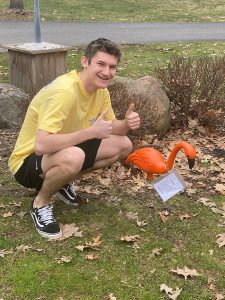 A student with a flamingo on his front lawn