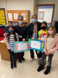 Students deliver a poster of thanks to the school nurses.