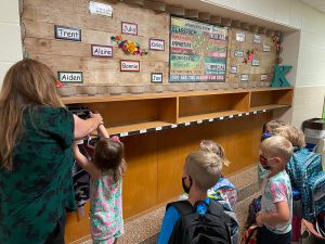 A teacher helps a student on the first day of school