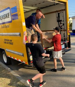 Individuals unload the Penske truck.