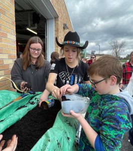 student add soil to their milk jugs