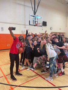 Tay Fisher takes a selfie with middle school students