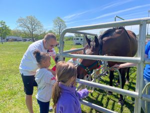 Teacher Andy Jennings and students interact with a horse