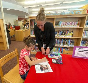 Principal Beckett receives a signed bookmark by Aliannah Young.