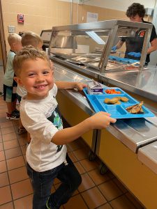 An elementary student going through the lunch line