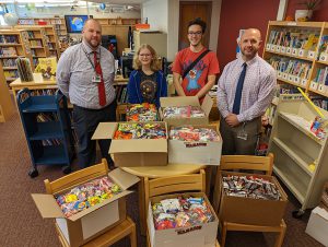 Principal James Ducharme and Assistant Principal Nate Kocak with high school students and the Treats for Troops candy.