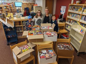 Principal Rose Beckett with elementary students and the Treats for Troops candy.