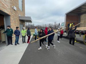 students assist unloading the Curtis Lumber truck