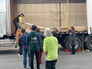 students begin unloading the Curtis lumber wood donation