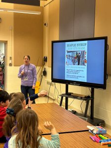 Grace Rathbun talks to first graders about how maple syrup is produced