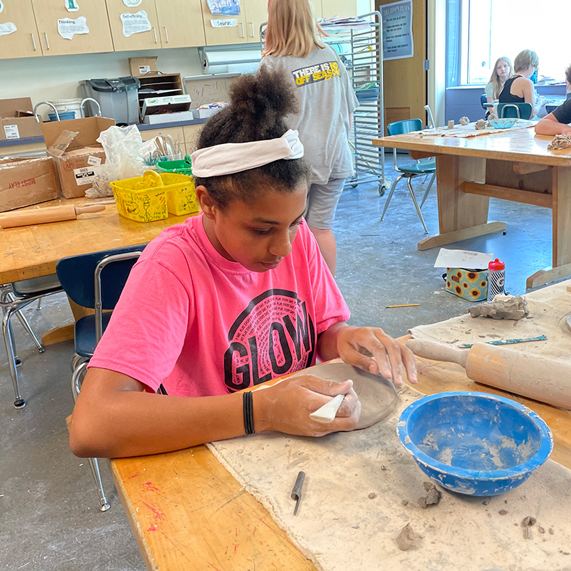 Girl molds clay with hands