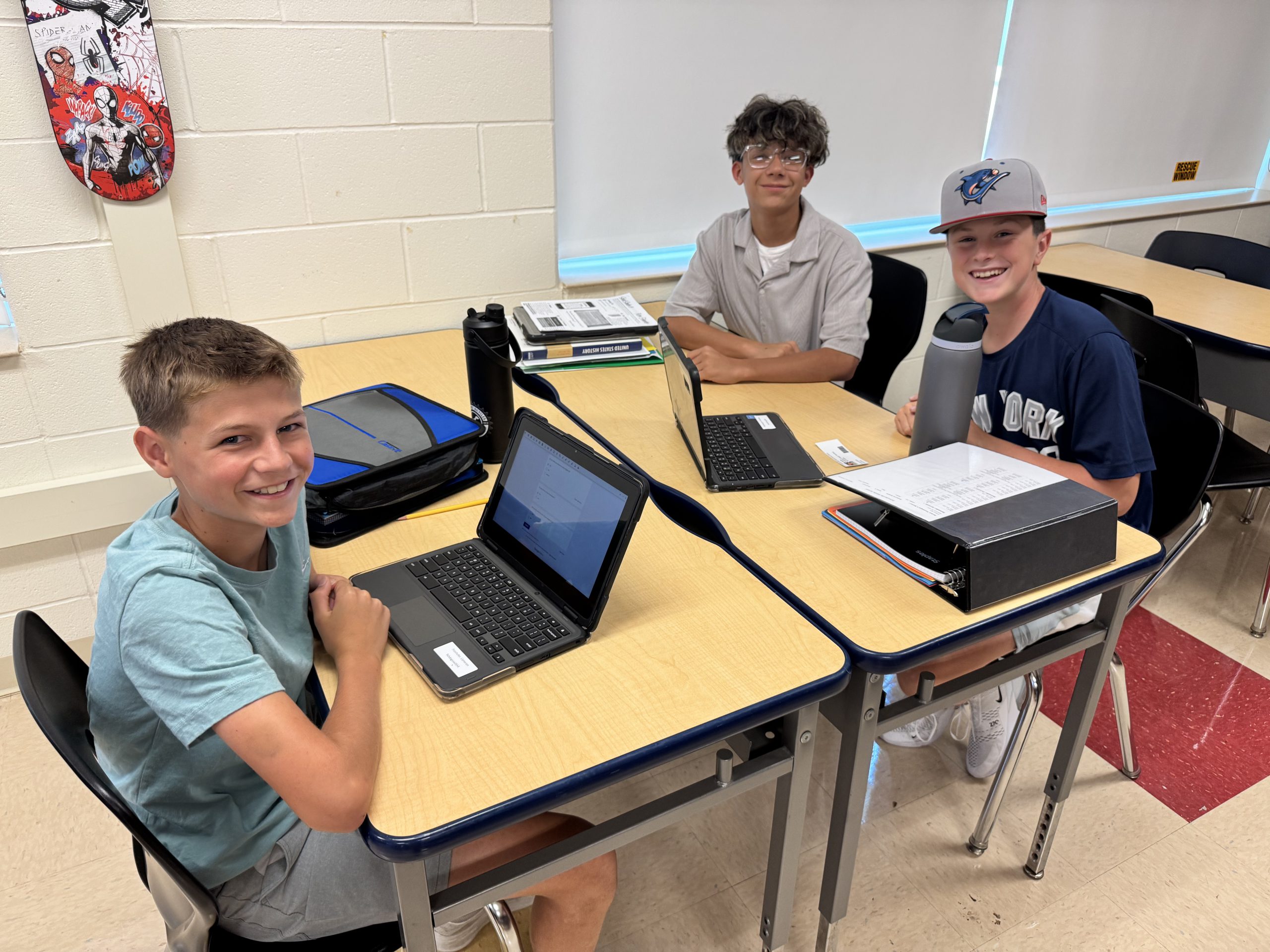 Three 8th grade students working on Chromebooks