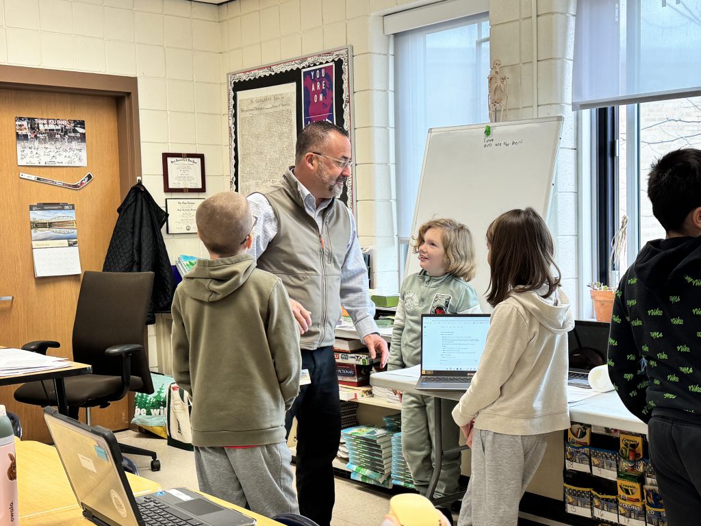Pete Carner works with students during a lesson using the Gemini AI platform.