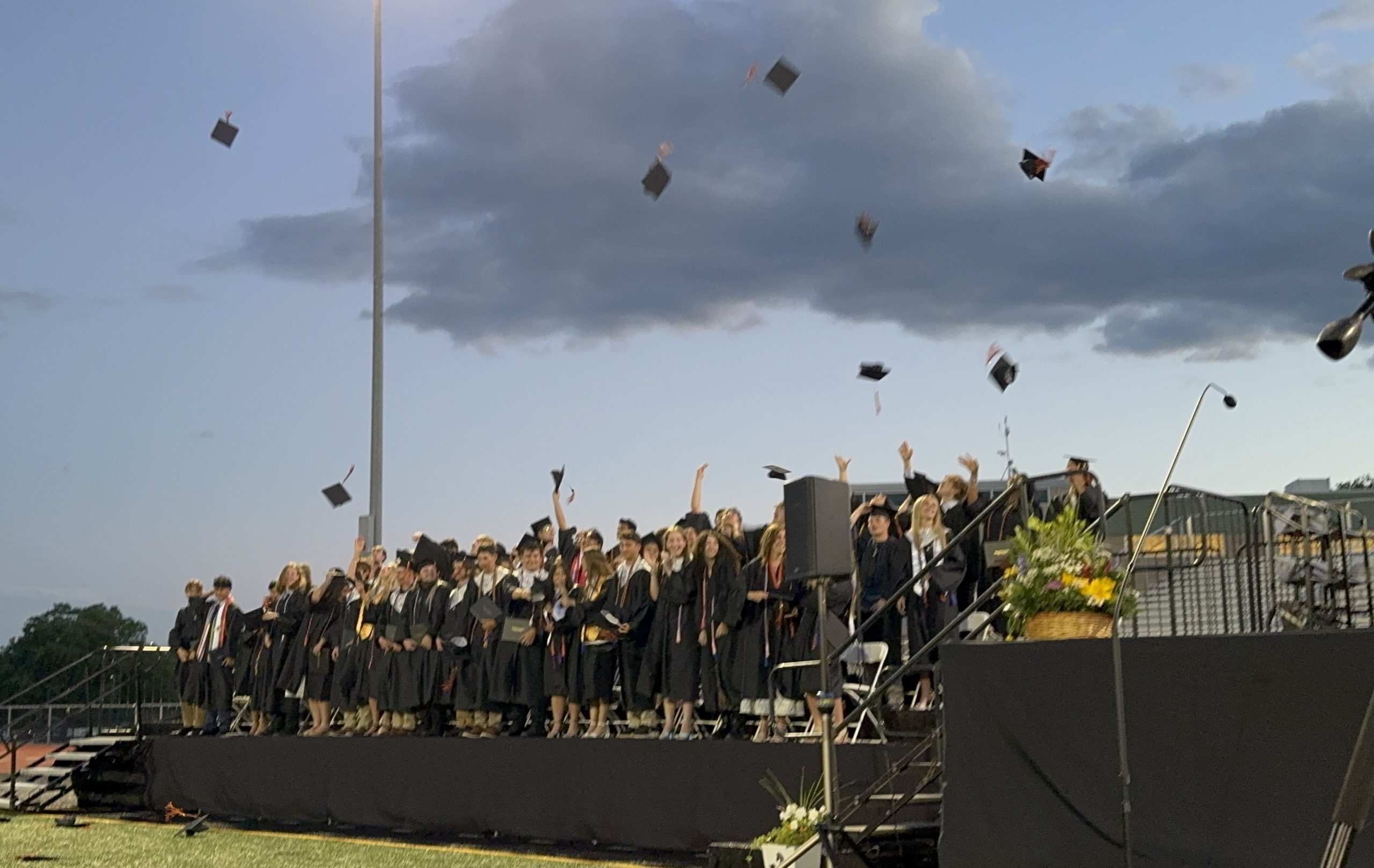 Students throw their graduation caps in the air